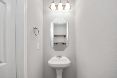 The powder room featuring a pedestal sink, a geome