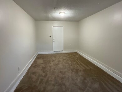 Empty room featuring a textured ceiling and dark c