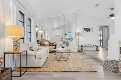 Living room with wood finished floors, vaulted cei