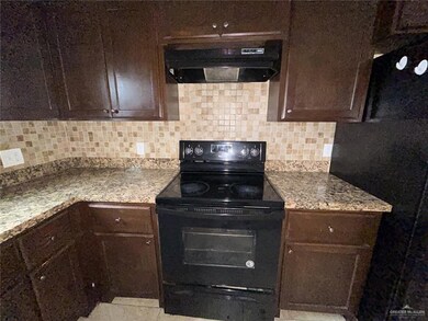 Kitchen with tasteful backsplash, dark brown cabinetry, black / electric stove, and under cabinet range hood