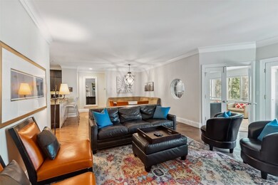 Living room with ornamental molding, a chandelier,