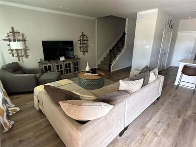 Living room with ornamental molding and hardwood / wood-style flooring