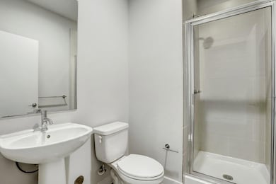 Full bathroom with toilet, a shower stall, a sink
