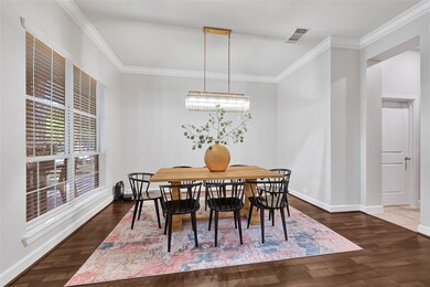 Dinning has a large window with natural light, a contemporary light fixture, and an open doorway leading to Kitchen.