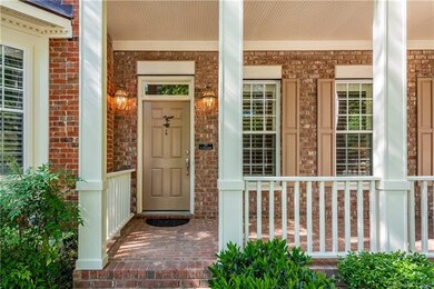 Deep, brick front porch with bead board ceiling is