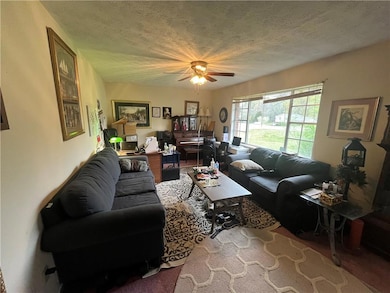 Living area with ceiling fan and a textured ceilin