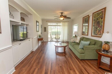 Living room featuring ornamental molding, dark woo