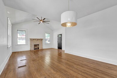 Unfurnished living room featuring a fireplace, dar