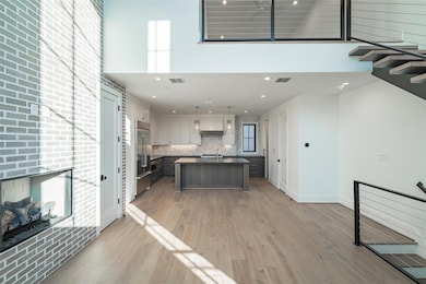 Kitchen with a towering ceiling, light wood-type f