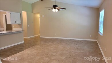Living area of great room w vaulted ceiling, beautiful tile floors and breakfast bar