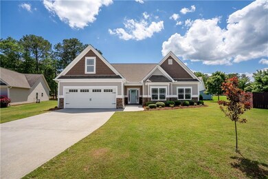 Craftsman-style house featuring stone siding, driv