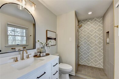 Bathroom featuring vanity, a tile shower, and recessed lighting