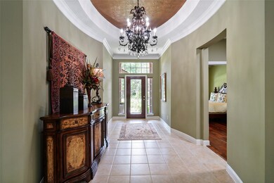 Formal entry with eye catching oval ceiling accented by a gorgeous bronze and crystal chandelier. Crown molding accent the space and curved walls create architectural interest. One of the three guest bedrooms and guest bath is just off of this entry hallway.