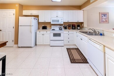 Kitchen featuring white cabinets, light tile patte