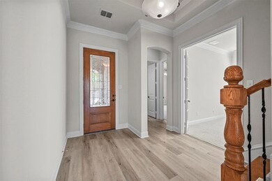 Foyer entrance featuring ornamental molding and li