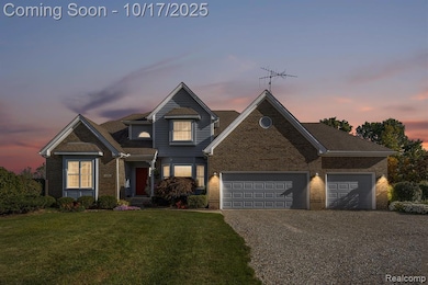 Traditional-style house with driveway, brick siding, a front yard, and an attached garage