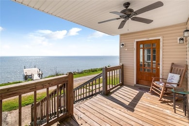 Wooden deck with a water view and ceiling fan