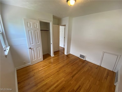 Unfurnished bedroom featuring light wood-style floors, a closet, and a textured ceiling