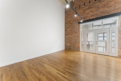 Living Area with Original Exposed Brick Wall & High Ceilings