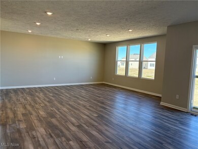 Empty room featuring dark wood-style floors, a textured ceiling, and recessed lighting