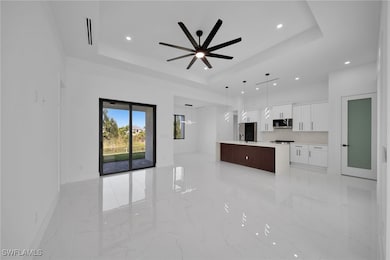 Unfurnished living room featuring a raised ceiling