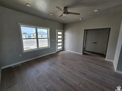 Spare room with ceiling fan, a textured ceiling, and light wood-type flooring