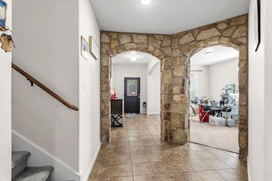 Corridor with arched walkways, stairway, tile pat