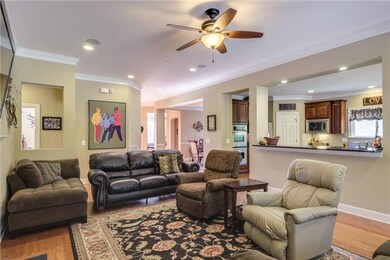 Great Room with upgraded Hunter ceiling fan and lighting fixture connects to huge kitchen pass through with upgraded extended granite counter fit for bar stools and entertaining! 