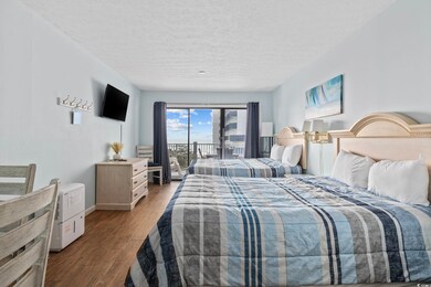 Bedroom featuring access to exterior, a textured ceiling, wood finished floors, and baseboards