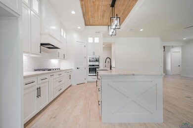 Kitchen with a kitchen island with sink, hanging l