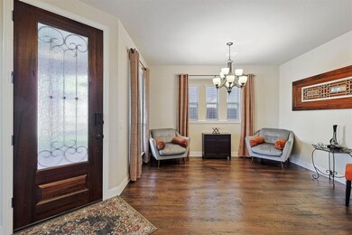 Foyer with a chandelier and hand-scraped hardwood style flooring