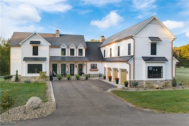 Modern farmhouse style home with a standing seam roof, a metal roof, a front lawn, and a chimney