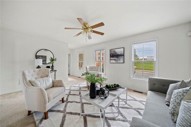 Living room with light colored carpet and ceiling fan