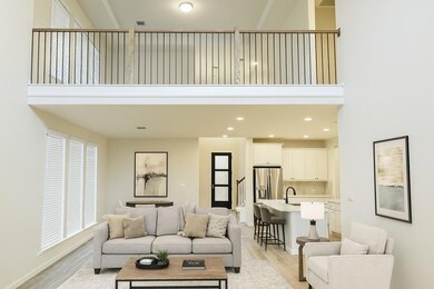 Living room featuring a high ceiling, light wood-