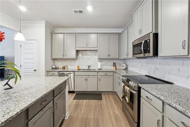 Kitchen with sink, gray cabinetry, crown molding, 