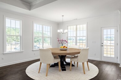 Dining area featuring an inviting chandelier, dark wood-type flooring, and a wealth of natural light