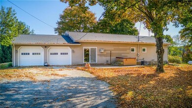 Ranch-style home with a garage and central AC unit