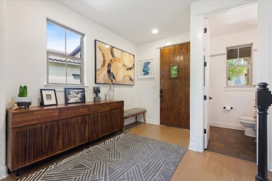 Entryway with wood finished floors, baseboards, a