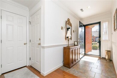Ceramic tiled foyer. The far left door is a coat c