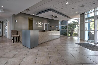 Reception area featuring floor to ceiling windows, a drop ceiling, and ceiling fan