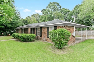 Ranch-style home with brick siding, a carport, and a shingled roof