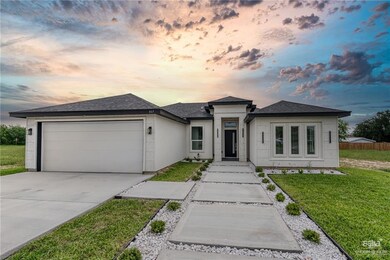 Prairie-style home with a shingled roof, a front lawn, driveway, and an attached garage