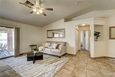 Living room featuring vaulted ceiling, light tile