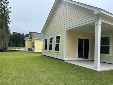 Rear view of house with a lawn, a patio, cooling u