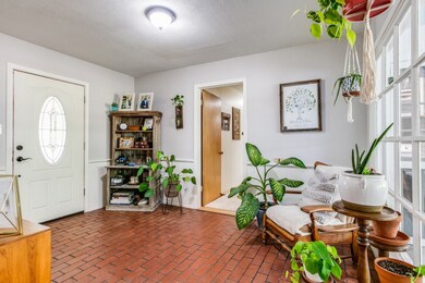 Large entry with brick floor leading to the bedroom wing of the home