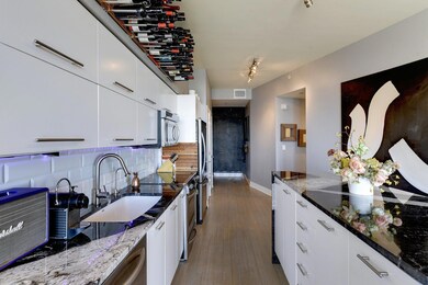 Kitchen featuring a sink, white cabinets, backspl