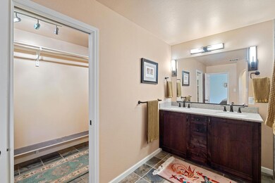 Full bath with double vanity and baseboards