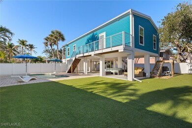 Back of property featuring a pool, an astroturf la