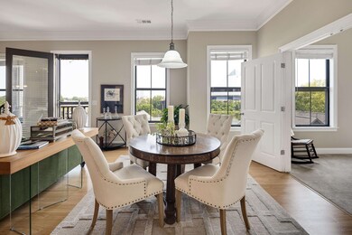 Dining space featuring healthy amount of natural light, crown molding, and light wood-type flooring