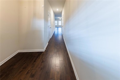 Hall featuring dark wood finished floors and recessed lighting